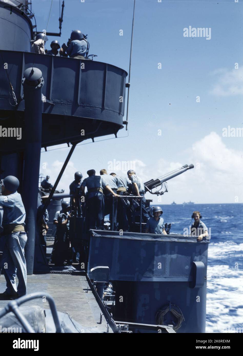 USS Mobile (CL-63) '40mm l'équipage du canon est prêt pour l'action. USS Mobile (CL-63) en route pour le raid sur l'île Marcus. D'autres navires de la force opérationnelle, deux transporteurs et BB, sont vus au large de fort Quarter. 1939 - 1958. Banque D'Images