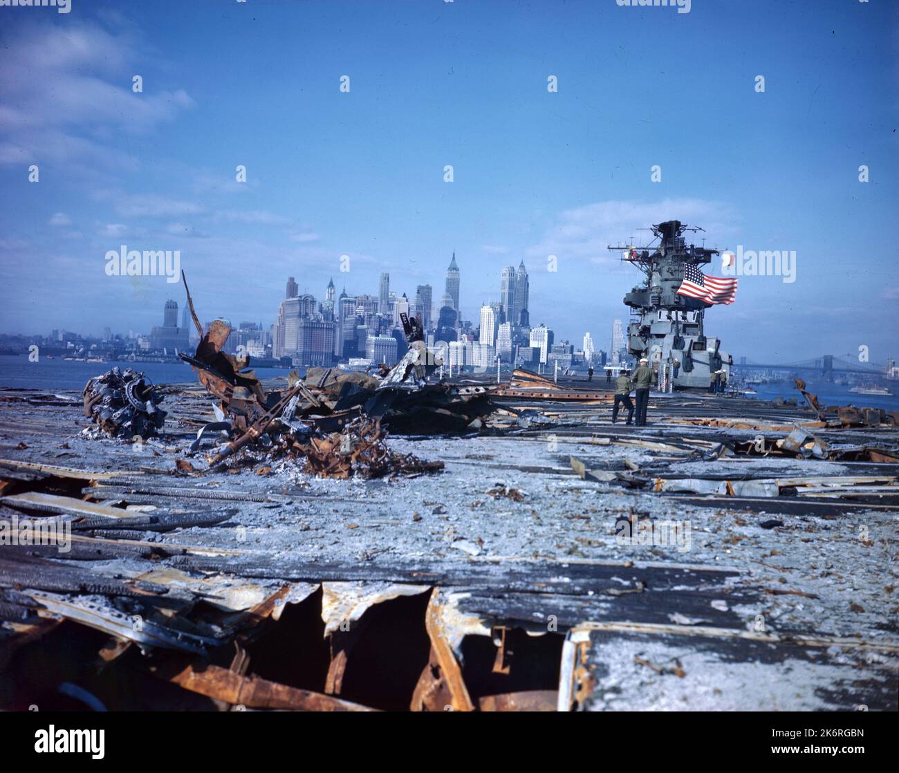 'USS Franklin (CV-13) de retour à Brooklyn Navy Yard pour des réparations suite à la bombe de Jap frappé sur 19 mars 1945 dans la mer intérieure, Japon. L'horizon de New York est beau pour les hommes alors que le bateau s'embarque dans le port de New York avec un vol « Old Glory ». » Légende sur le manchon négatif : « l'USS Franklin, un transporteur galant de la classe ESSEX, gravement endommagé par des bombes ennemies dans la mer intérieure japonaise, 19 mars 1945, retourne au triage de la marine de Brooklyn sous son propre pouvoir. » Banque D'Images