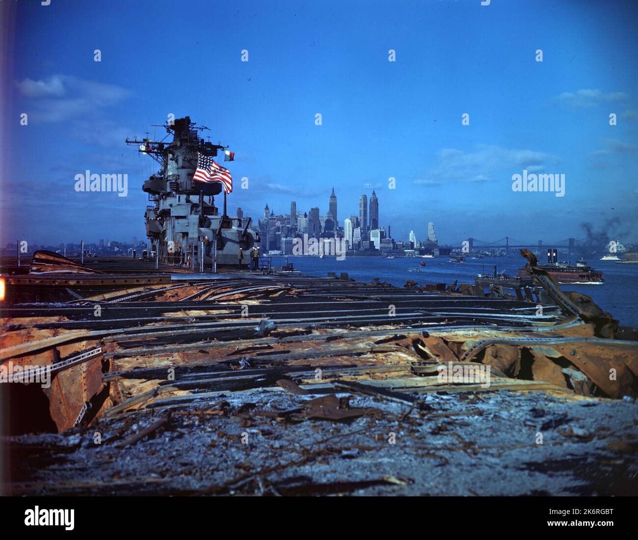 'USS Franklin (CV-13) de retour à Brooklyn Navy Yard pour des réparations suite à la bombe de Jap frappé sur 19 mars 1945 dans la mer intérieure, Japon. « Old Glory », volant de son mât cassé, le brave Flat-top entre dans le port de New York. » Légende sur le manchon négatif : « l'USS Franklin, un transporteur galant de la classe ESSEX, gravement endommagé par des bombes ennemies dans la mer intérieure japonaise, 19 mars 1945, retourne au triage de la marine de Brooklyn sous son propre pouvoir. » Banque D'Images