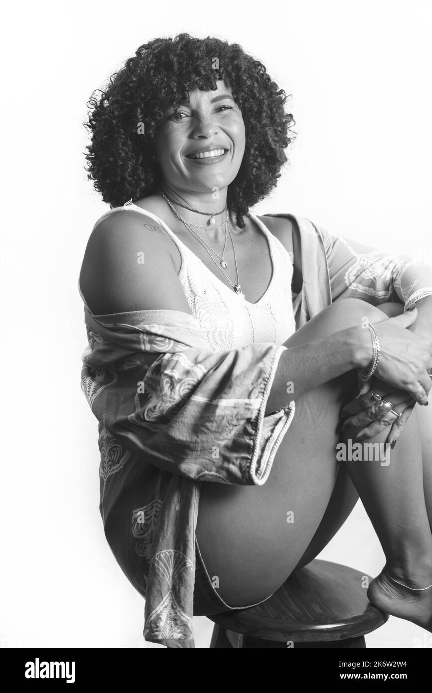 Portrait noir et blanc d'une femme aux cheveux bouclés. Beau et souriant sur fond clair. Femme mature. Concept d'estime de soi. Banque D'Images
