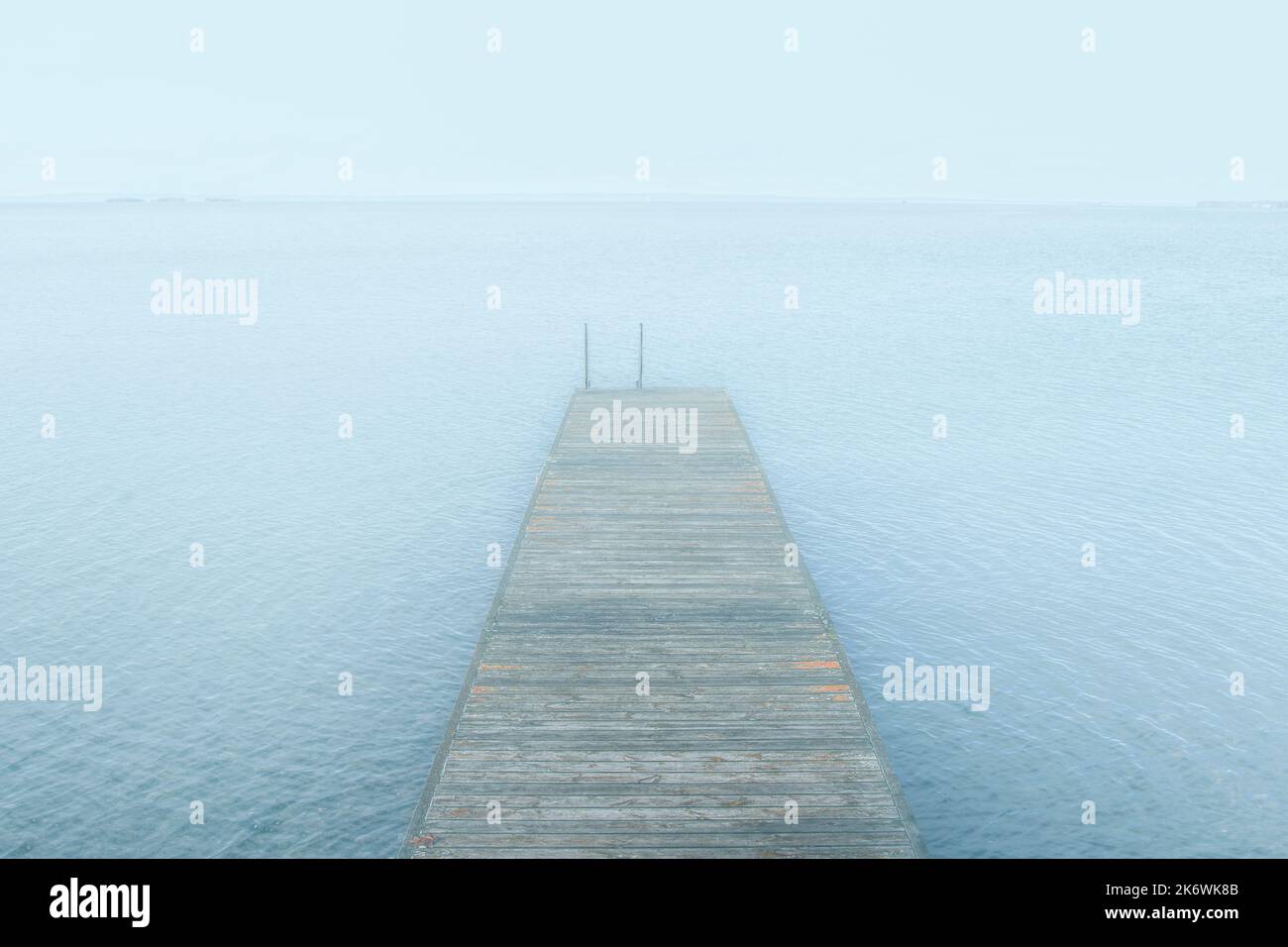 Jetée en bois sur le lac dans le brouillard une journée calme en sérénité Banque D'Images
