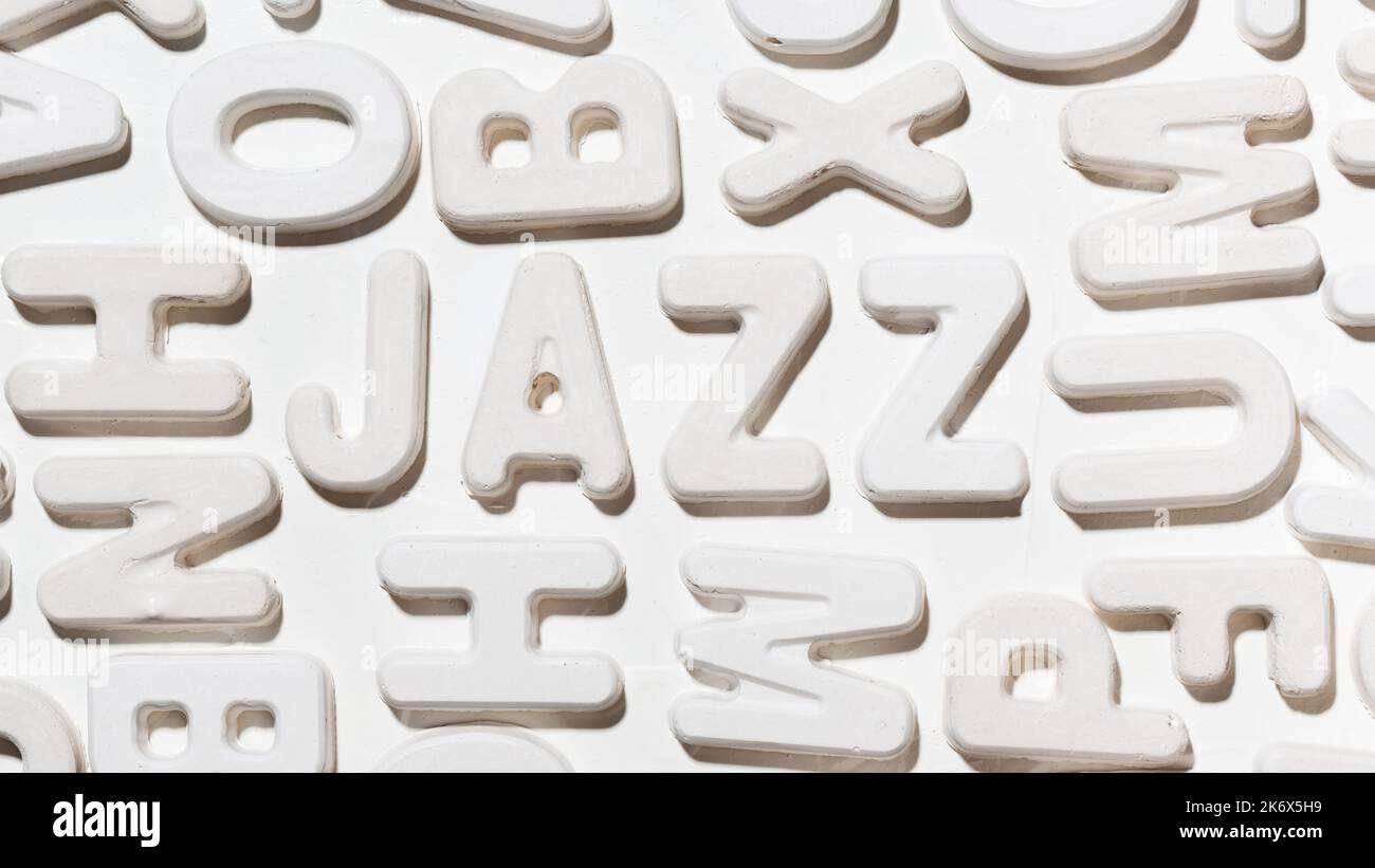 Mot de jazz entouré de lettres moulées blanches aléatoires. Gros plan sur l'inscription Banque D'Images