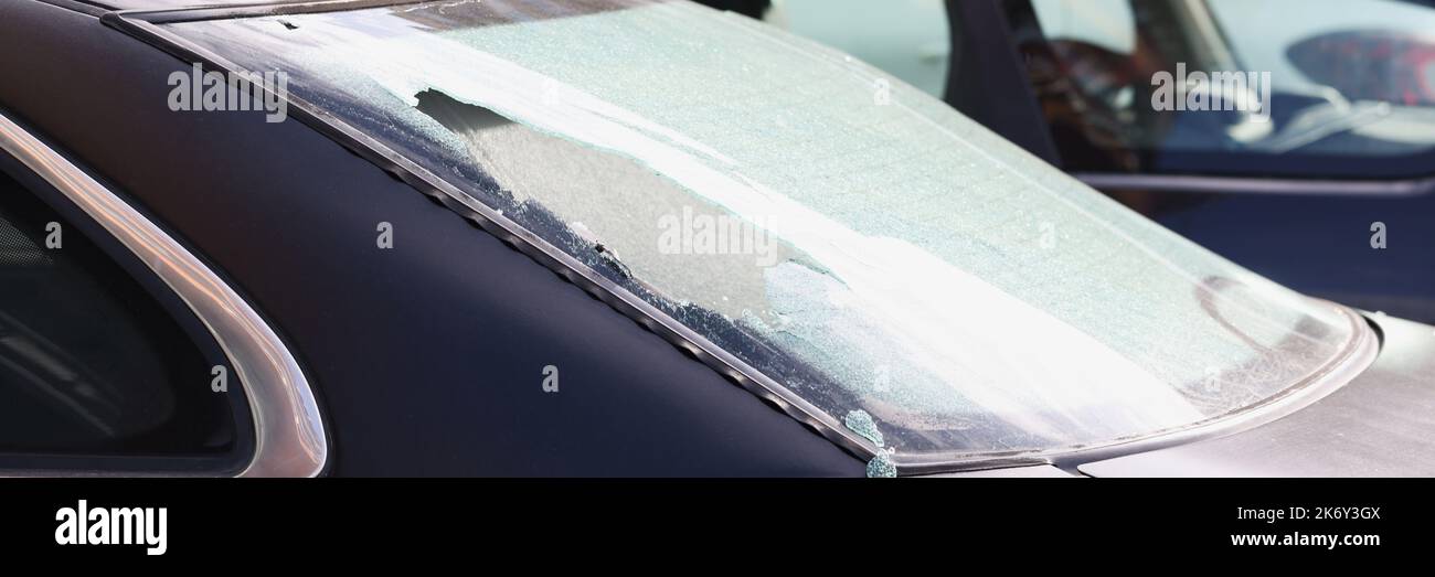 Vitre arrière cassée d'une voiture noire dans la rue, gros plan Banque D'Images