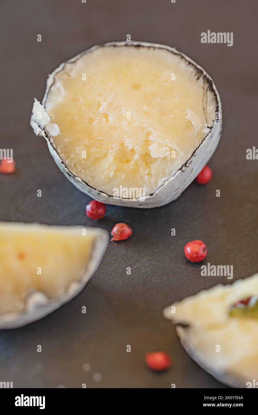 Une vue rapprochée des boulettes de viande avec ail et poivre rose dans la cendre de bois. Fromage suisse. Fromage fermenté lactique. SDOF Banque D'Images