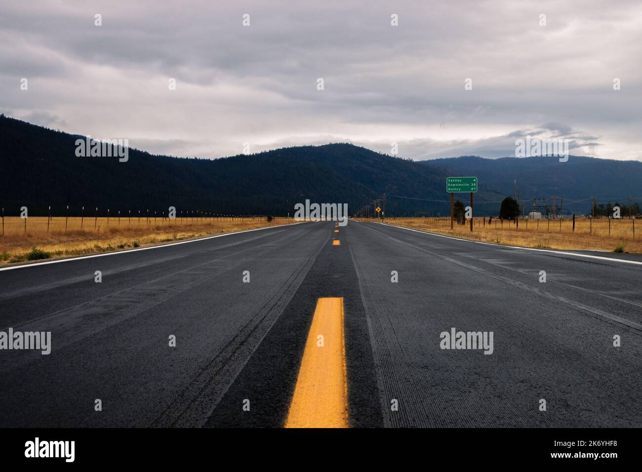 Une route vide en Amérique par temps nuageux. Route vide en Californie passant par un champ jaune avec une vue sur les montagnes à une distance Banque D'Images