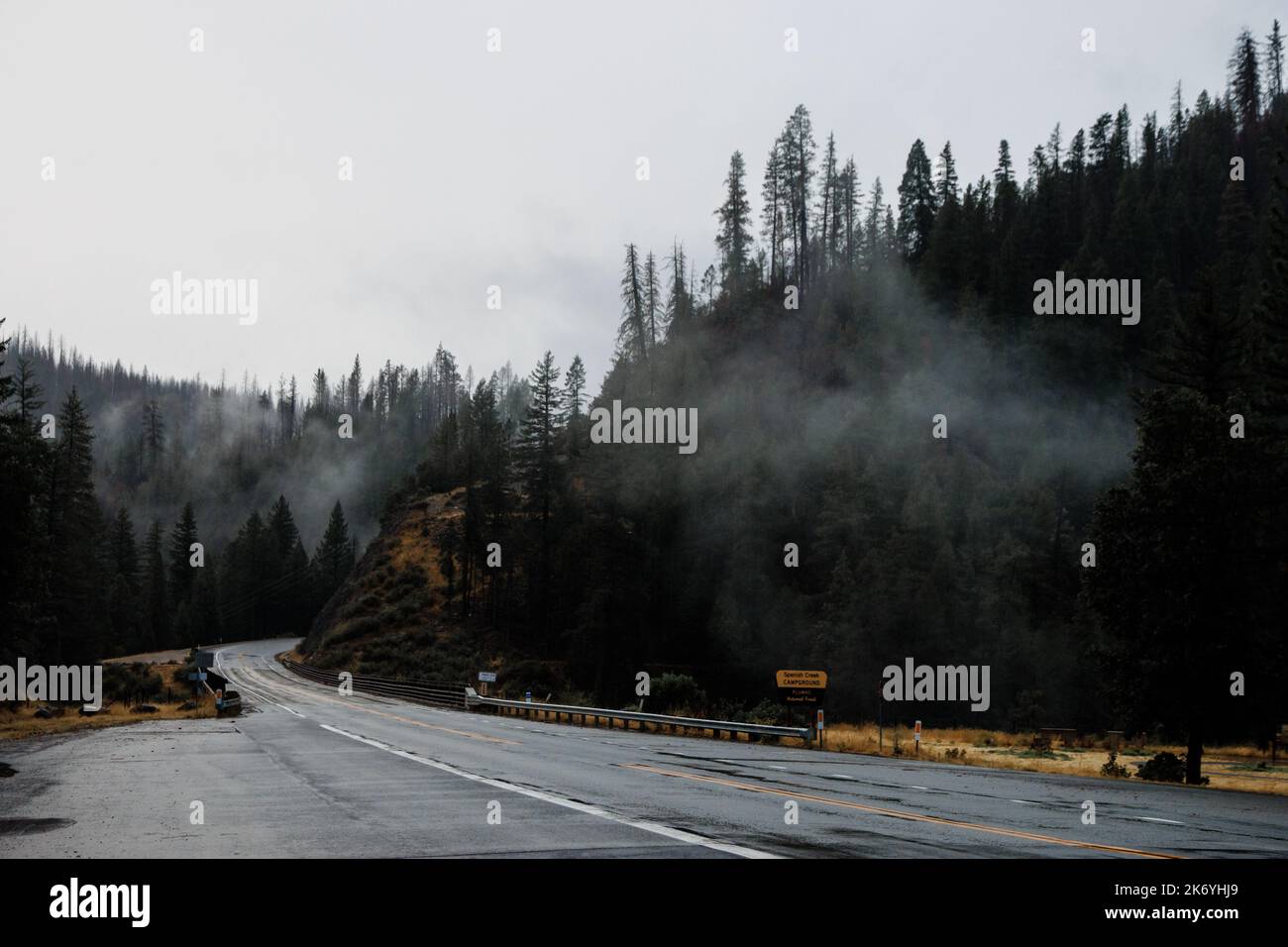Des nuages fins au-dessus de la route de montagne vide en Californie. Route dramatique et brumeuse le soir Banque D'Images