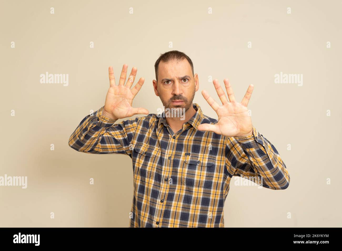 Vue de face d'un homme caucasien aux cheveux courts portant une chemise à carreaux avec ses mains paumes devant lui, avec la caméra face à la paume Banque D'Images