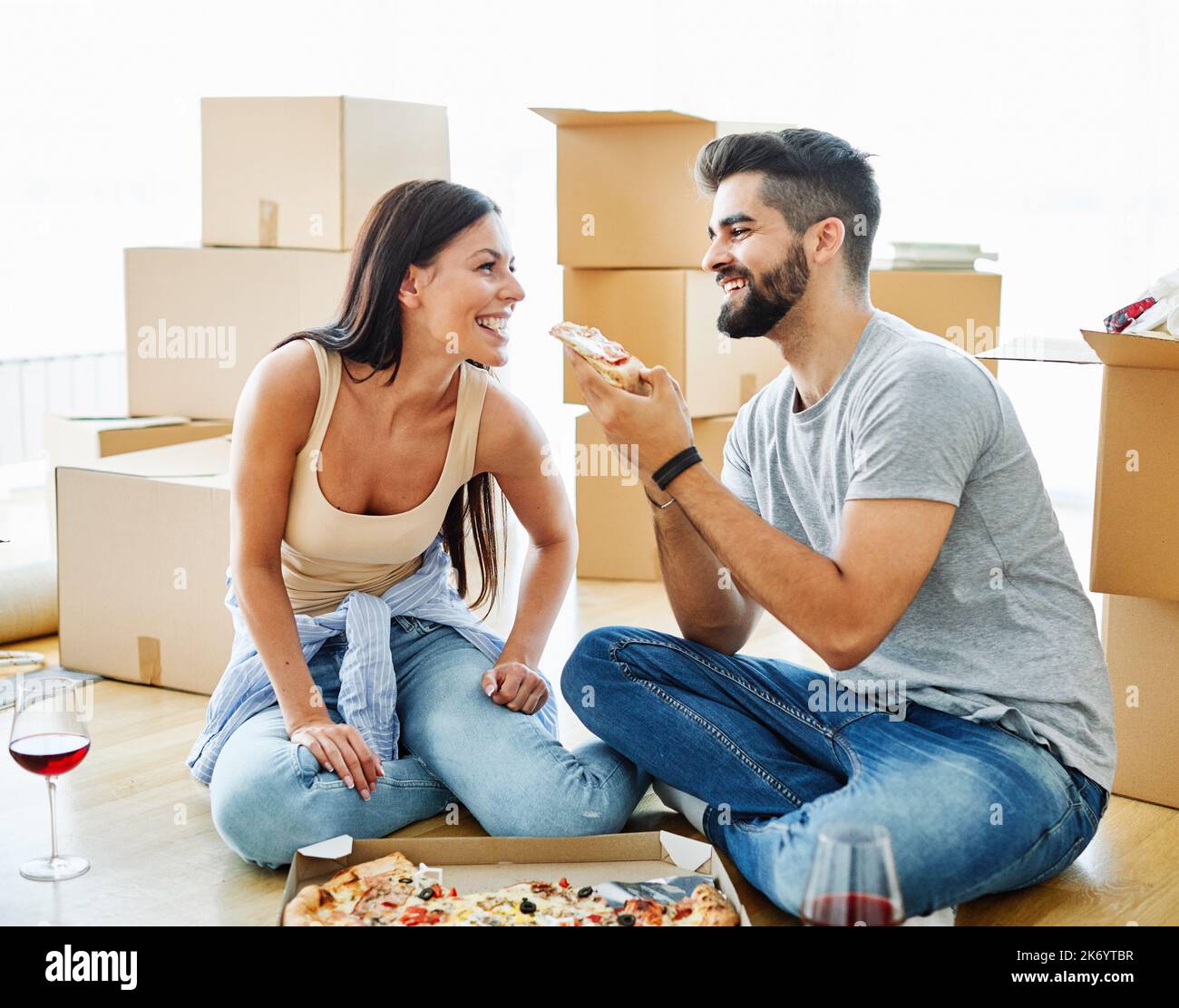 femme couple homme boîte maison déménagement appartement heureux ensemble romantique relocation pizza manger Banque D'Images