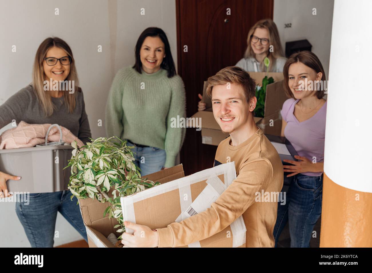 Souriant riant positif les étudiants se déplacent dans le nouveau campus, regardant la caméra, tenant des boîtes en carton avec des trucs. Université Banque D'Images