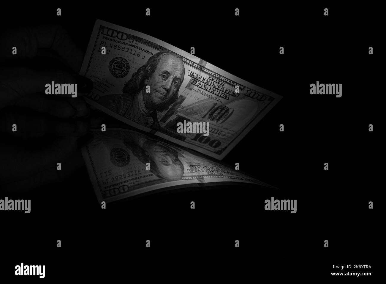 Cent dollars se trouvent sur un miroir dans la sombre gros plan noir et blanc photo, argent et affaires Banque D'Images