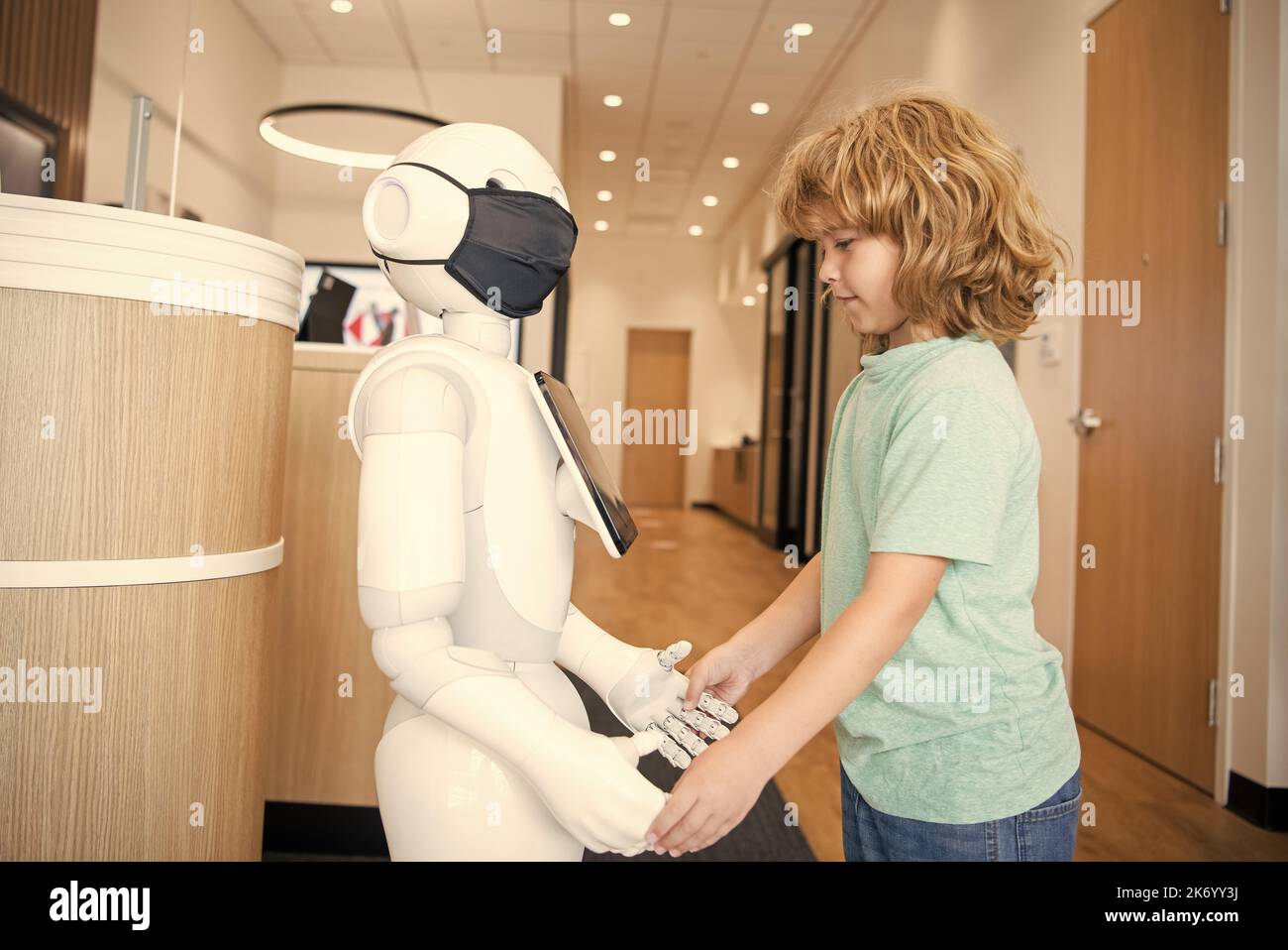 un petit garçon interagit avec le robot comme technologie innovante, communication Banque D'Images