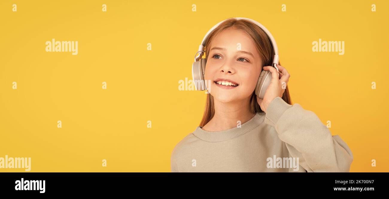mélomane. écoutez de la musique. accessoire de casque sans fil. Portrait d'enfant avec casque, affiche horizontale. Fille écoutant de la musique, bannière Banque D'Images