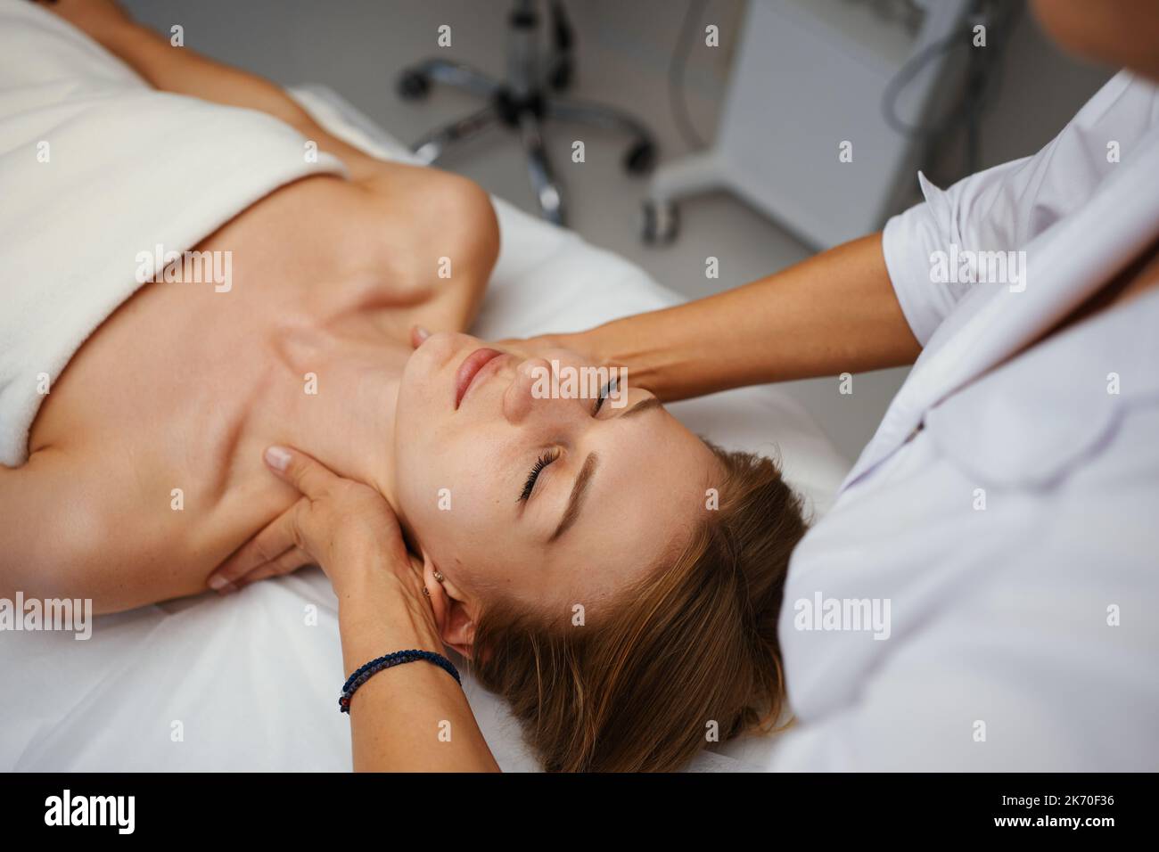 Massage du visage. Jeune jolie femme ayant un massage du visage dans le salon Banque D'Images