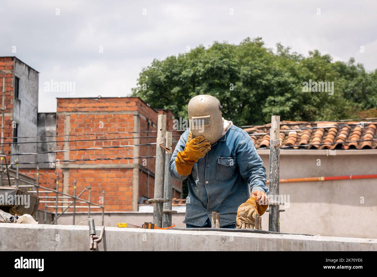 Travailleur portant un masque de soudeur sur la construction de la nouvelle route Banque D'Images