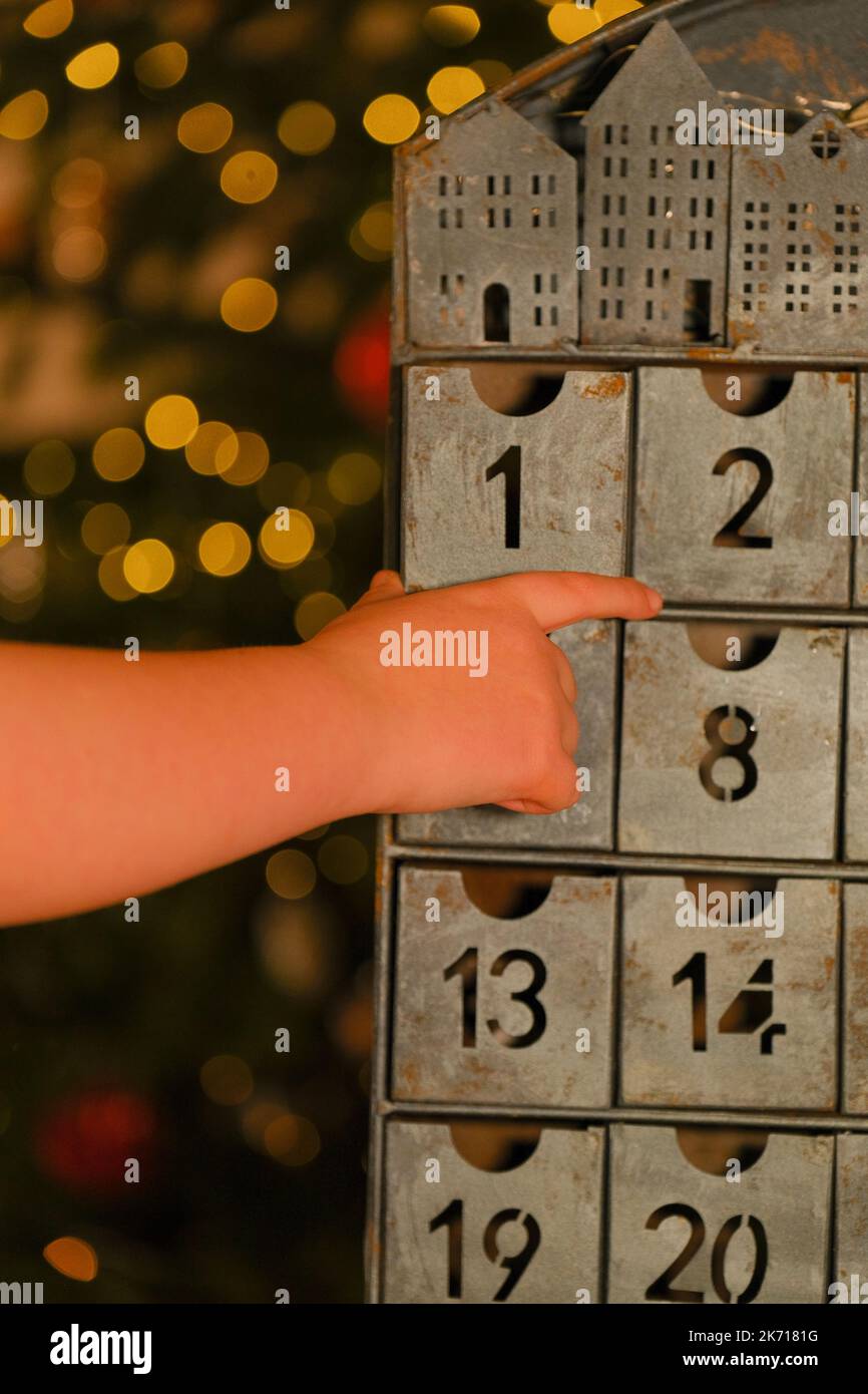 calendrier de l'avent de style vintage et main d'enfant sur fond de guirlande. Traditions et symboles.cadeaux et surprises pour Noël et le nouvel an Banque D'Images