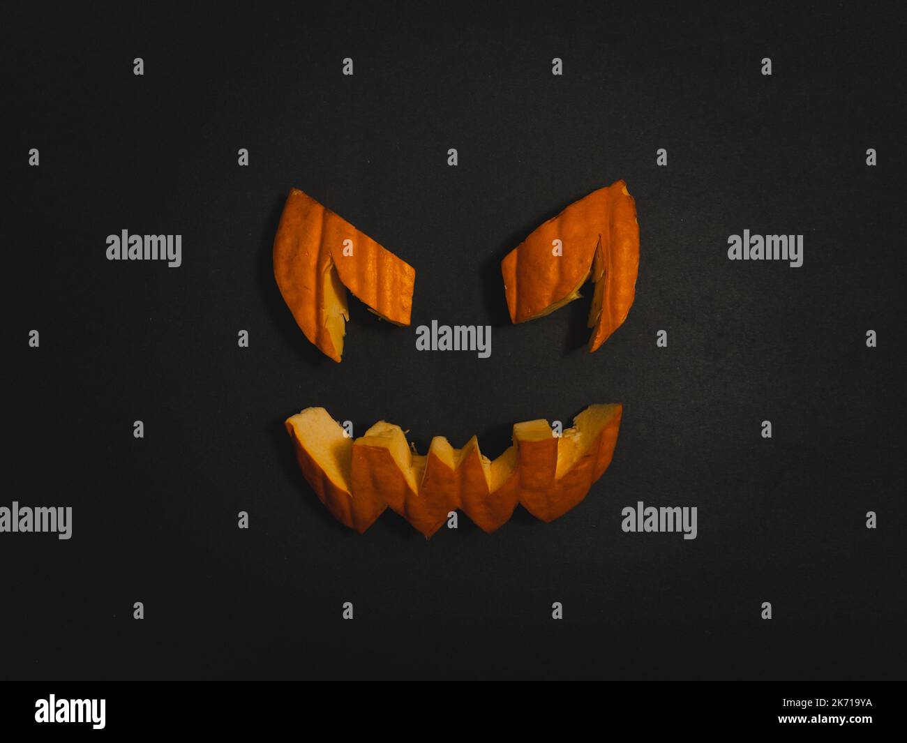 Véritable visage de citrouille orange d'Halloween morceaux sculptés sur fond noir donnant des vibes effrayants de saison. Portrait de sourire de citrouille effrayant illuminant à l'intérieur avec oran Banque D'Images