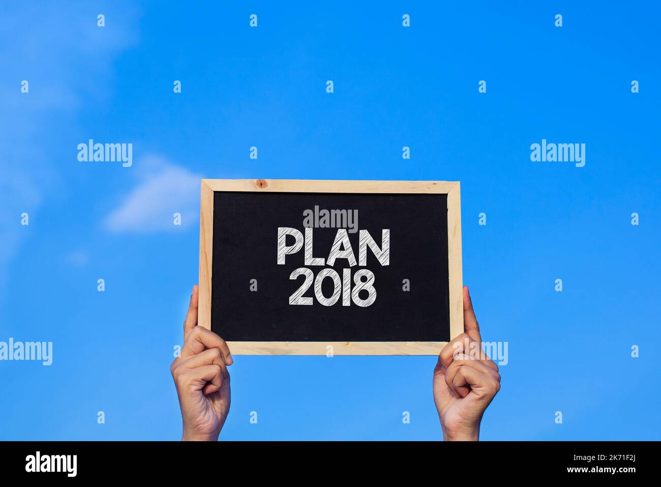 PLAN 2018 / Homme tenant un petit tableau noir sur fond bleu ciel Banque D'Images