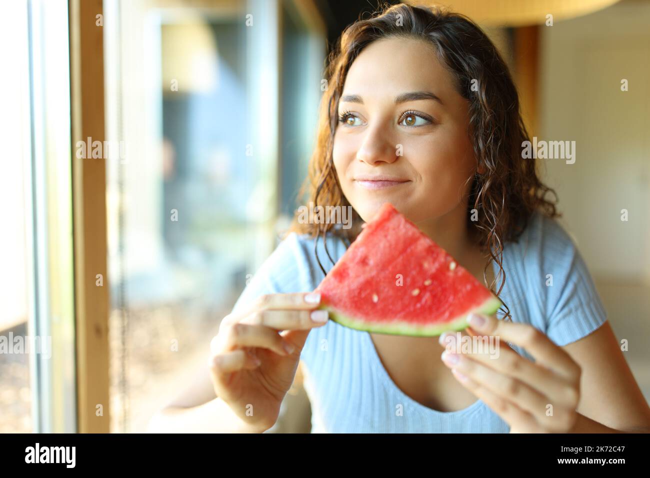 Bonne femme mangeant de la pastèque dans un restaurant Banque D'Images