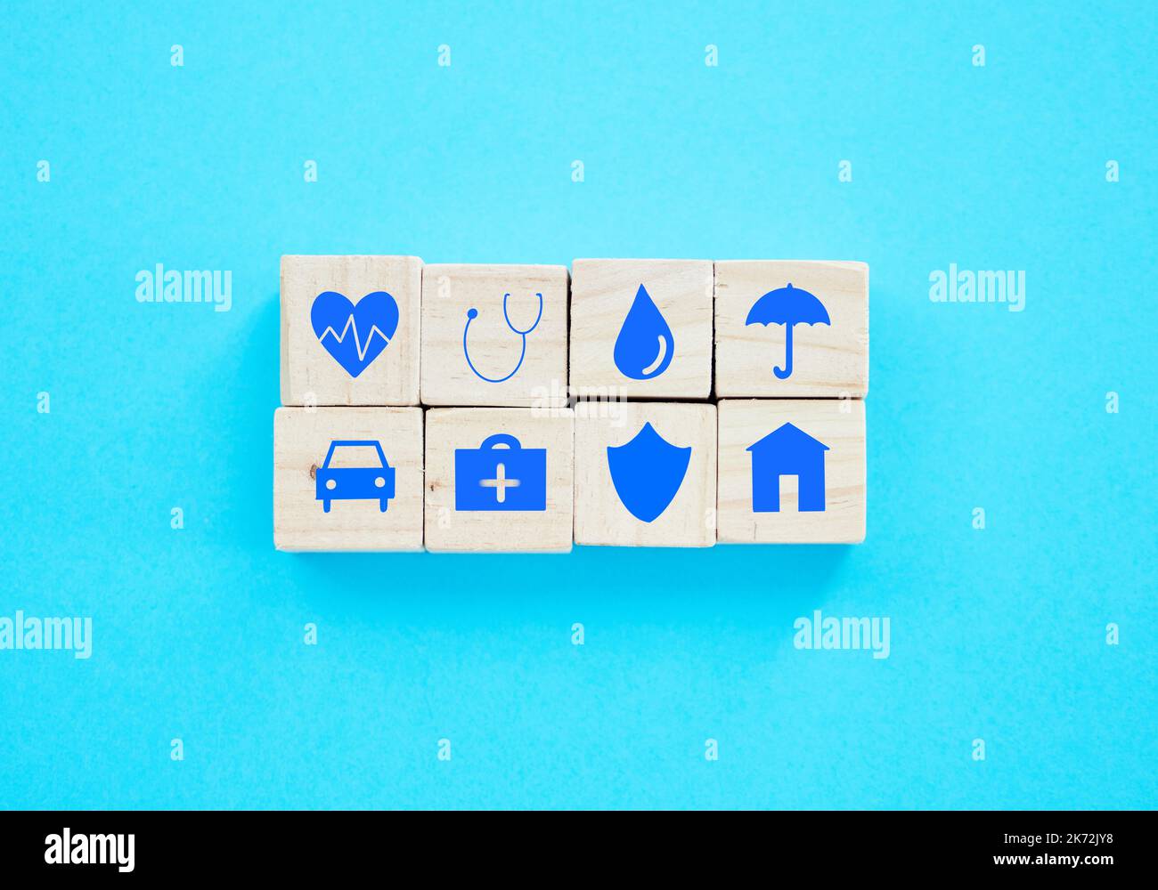 Pour toutes les petites choses de la vie. blocs en bois avec des symboles liés à l'assurance sur eux sur un fond bleu. Banque D'Images