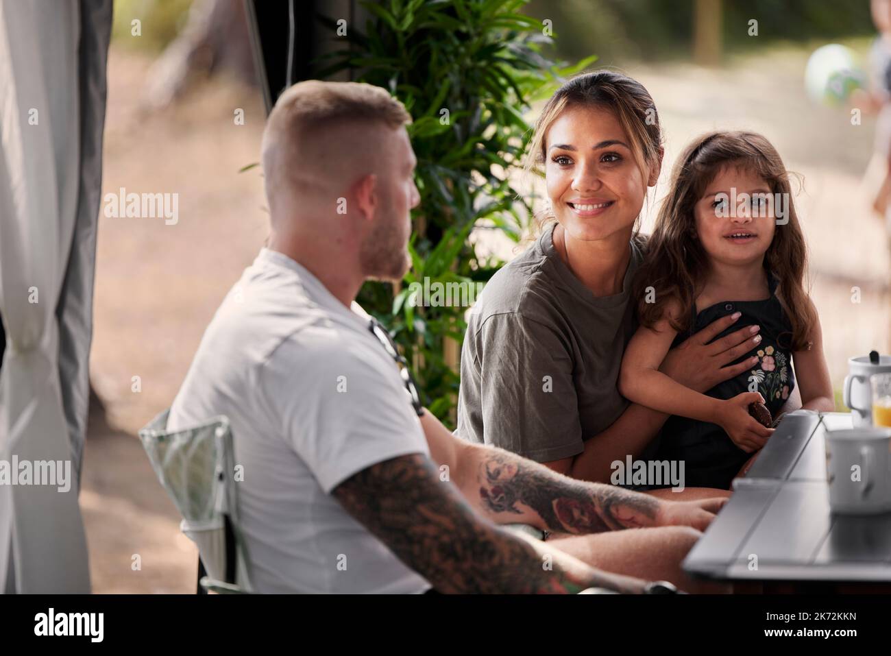 Famille avec fille assise à l'extérieur Banque D'Images