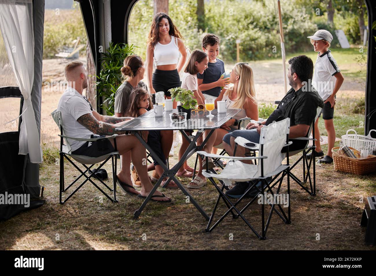 Amis avec des enfants se détendant sous le belvédère du jardin Banque D'Images