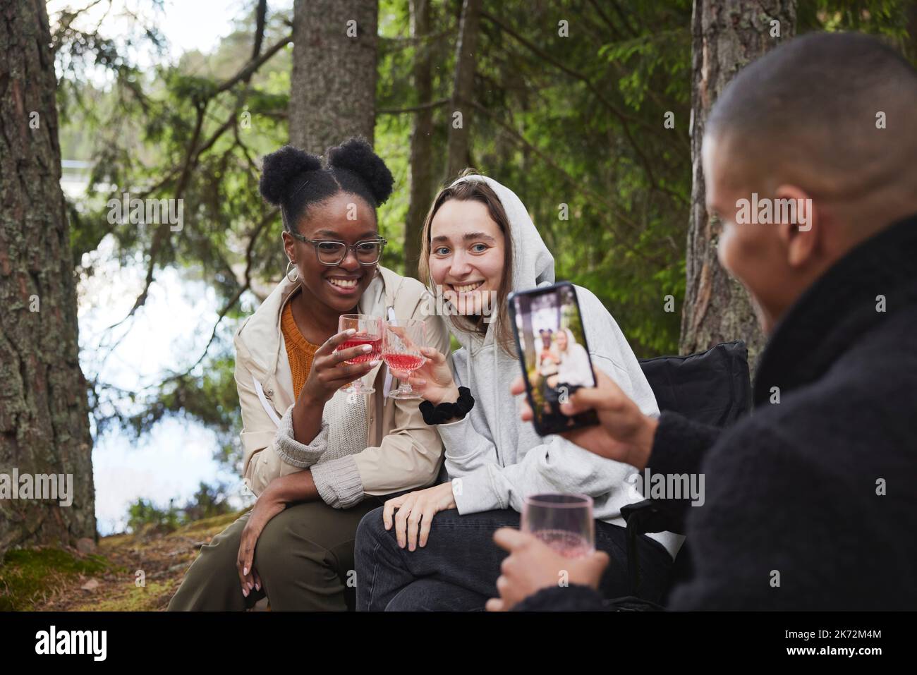 Amis qui boivent du vin en forêt Banque D'Images