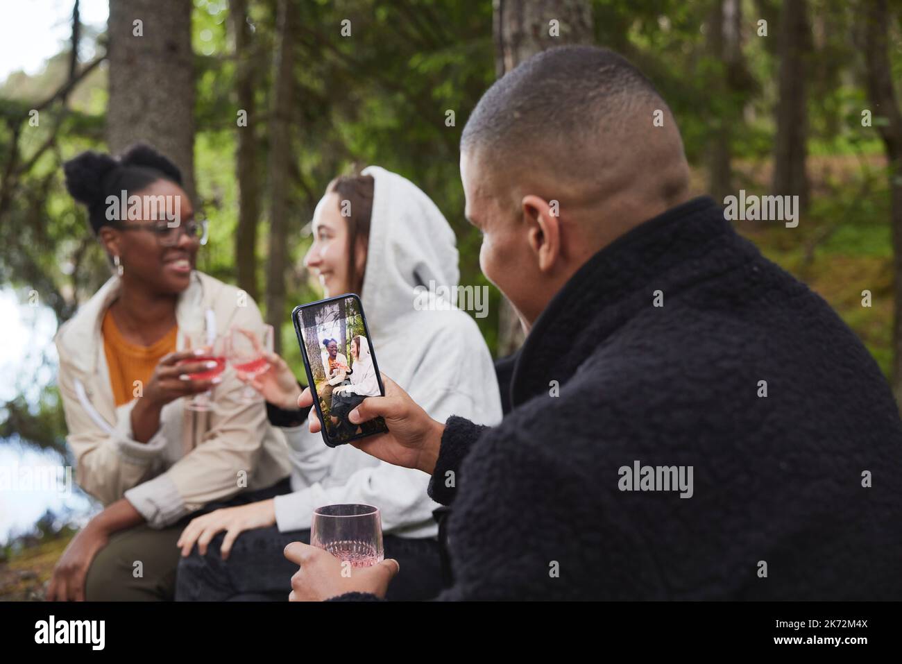 Amis qui boivent du vin en forêt Banque D'Images