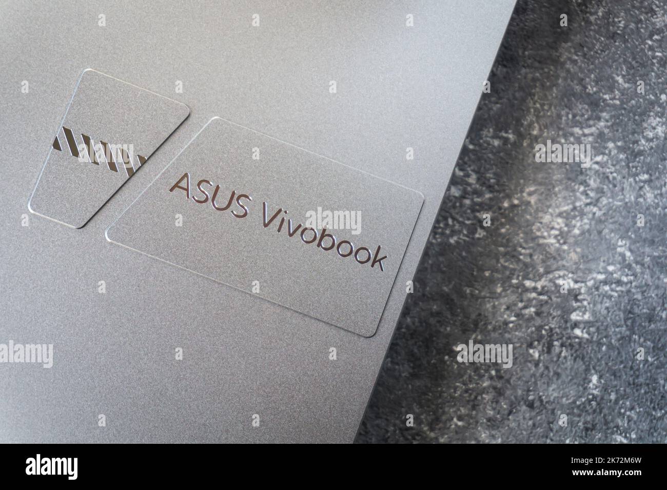 Gros plan du logo de l'ordinateur portable ASUS Vivobook pro 15 OLED, couleur argent frais, fond en béton. Varsovie, Pologne - 16 octobre 2022. Banque D'Images