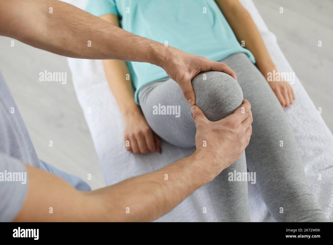Chiropraticien, ostéopathe ou physiothérapeute aidant la femme pendant la réadaptation après une blessure au genou Banque D'Images
