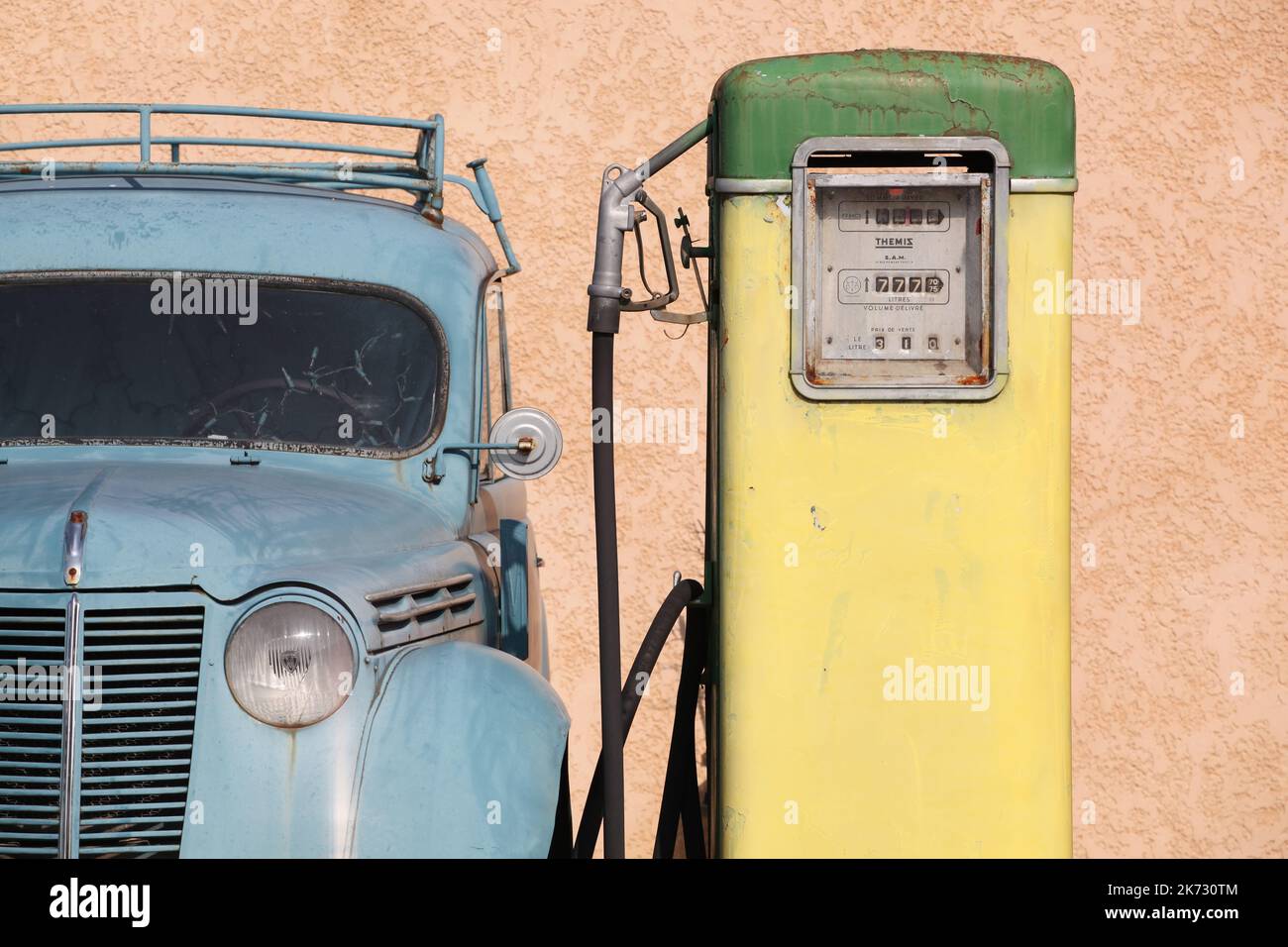 Oingt, France - 12 mars 2014 : pompe à gaz ancienne et ancienne avec voiture citroën en France Banque D'Images