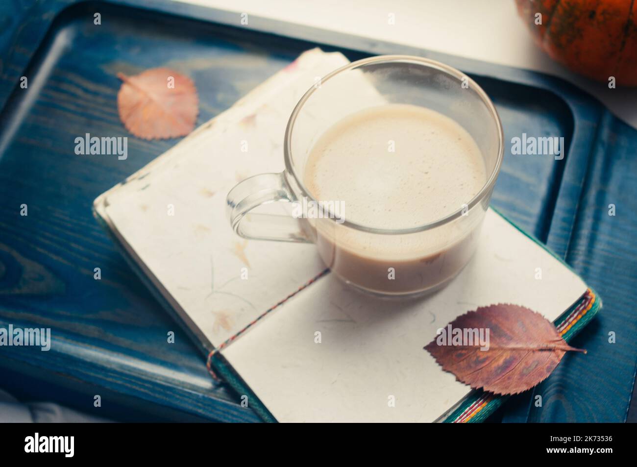 Une courge à la citrouille et un café latte à base de lait d'avoine ou de soja à base de plantes avec bloc-notes vierge à la table sur le b noir foncé Banque D'Images