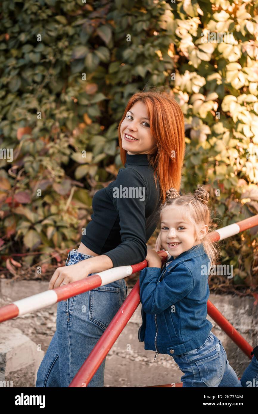 La mère élégante aux cheveux rouges et sa fille parlent