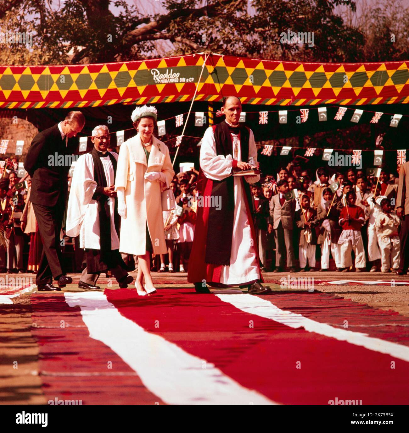 Photographie couleur vintage 1961 montrant la reine Elizabeth II en visite à la cathédrale de Lahore en Inde, avec l'évêque de Lahore, le révérend L. A. Woolmer. Fait partie de la visite indienne Queens 1961. Prince Phillip en arrière-plan. Banque D'Images