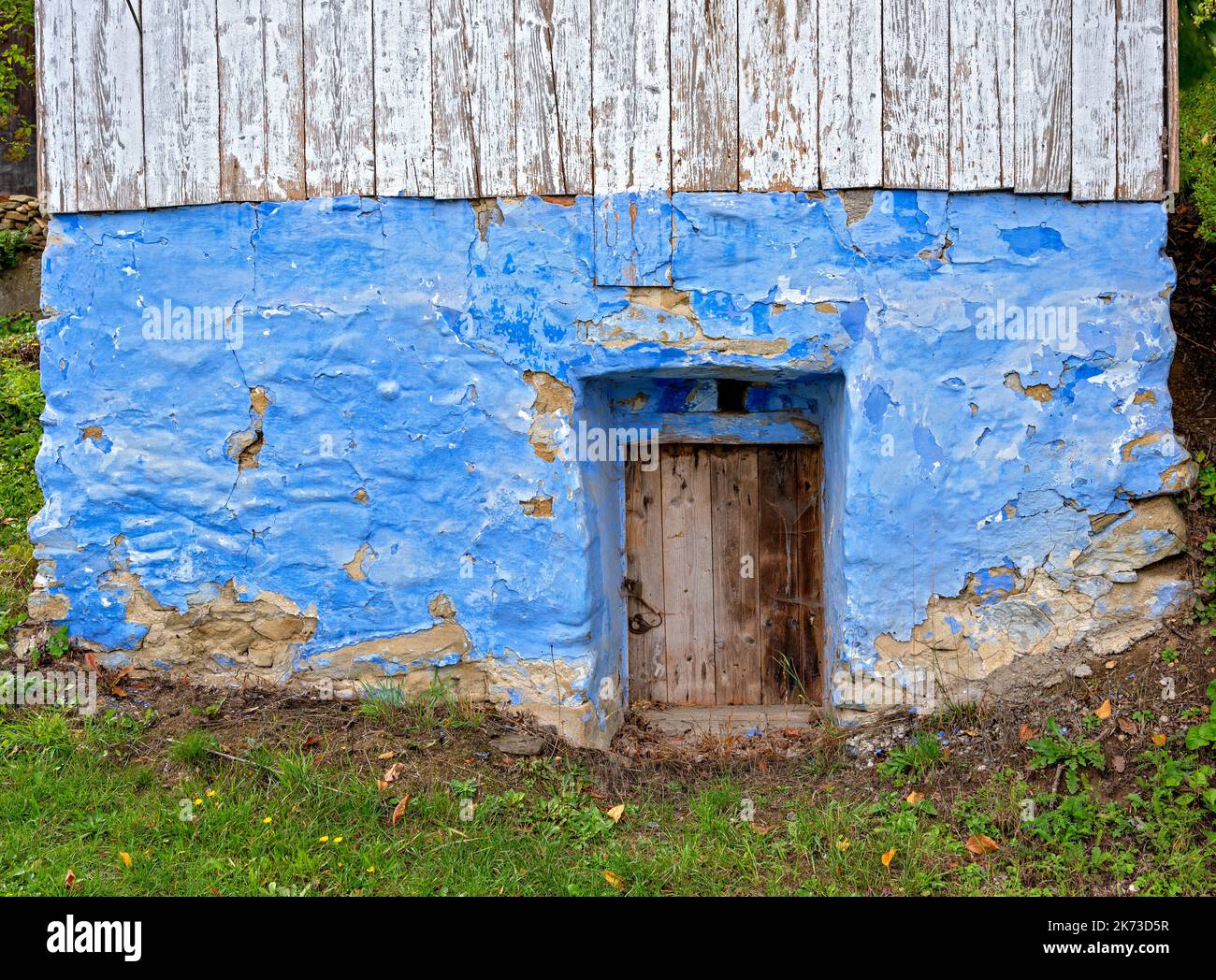 Porte en bois dans un sous-sol en pierre bleue traditionnelle desolate d'une maison à Hervartov, Slovaquie Banque D'Images