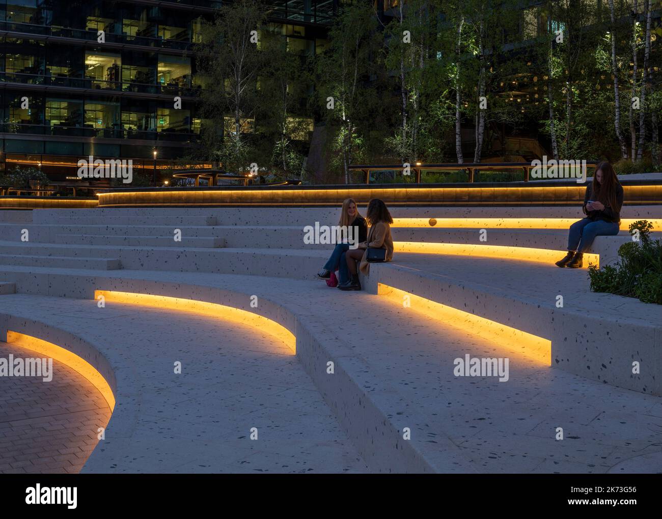 En soirée, vue sur la place avec la ville en arrière-plan. Exchange Square, Londres, Royaume-Uni. Architecte: DSDHA, 2022. Banque D'Images
