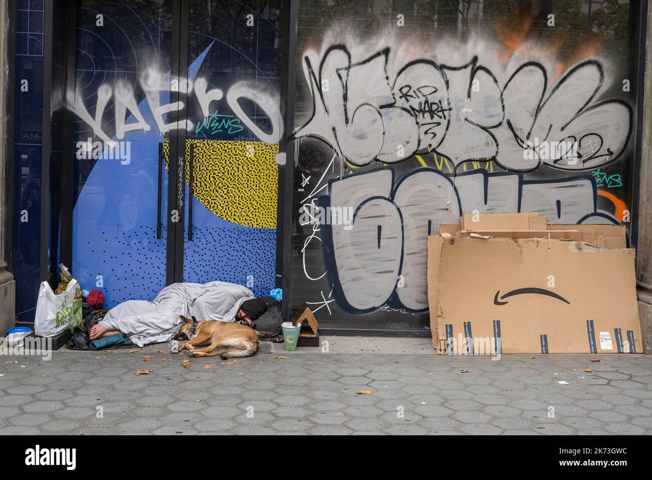 Barcelone, Espagne. 17th octobre 2022. Un homme sans abri vu à Passeig de Gràcia dormant accompagné de son animal de compagnie à côté d'un forfait Amazone. Signes de la mendicité et de la pauvreté à Barcelone à l'occasion de la Journée internationale pour l'élimination de la pauvreté, reconnue par les Nations Unies depuis 1992. (Photo par Paco Freire/SOPA Images/Sipa USA) crédit: SIPA USA/Alay Live News Banque D'Images