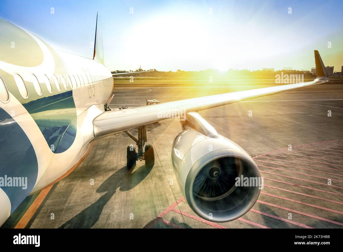 Avion à l'entrée du terminal prêt pour le décollage - aéroport international moderne pendant le coucher du soleil - concept de voyage émotionnel et de flâner dans le monde - L Banque D'Images