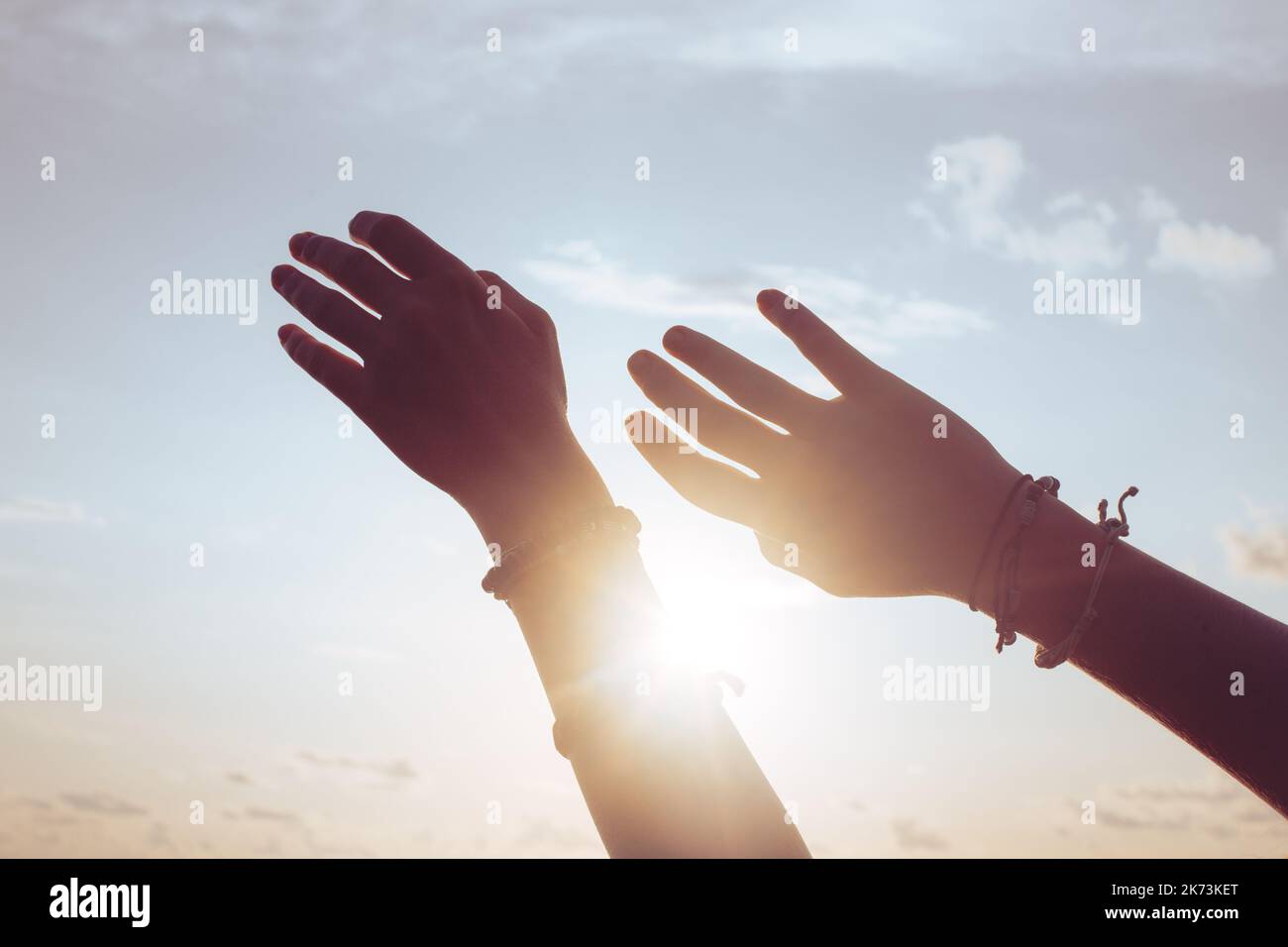 Femme mains contre le ciel bleu et le soleil Banque D'Images