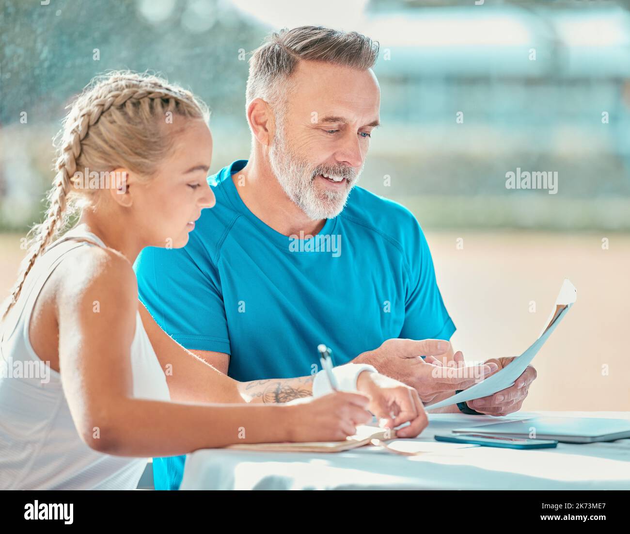 Je n'ai aucun doute youd faire le championnat. un beau coach mature assis avec un joueur de tennis et discutant d'un plan de jeu. Banque D'Images
