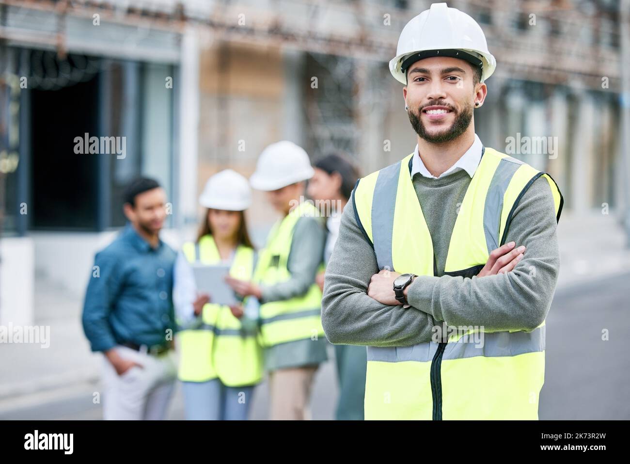 IBE a construit une grande équipe au fil des ans. un beau travailleur de la construction masculin debout avec ses bras repliés à l'extérieur. Banque D'Images