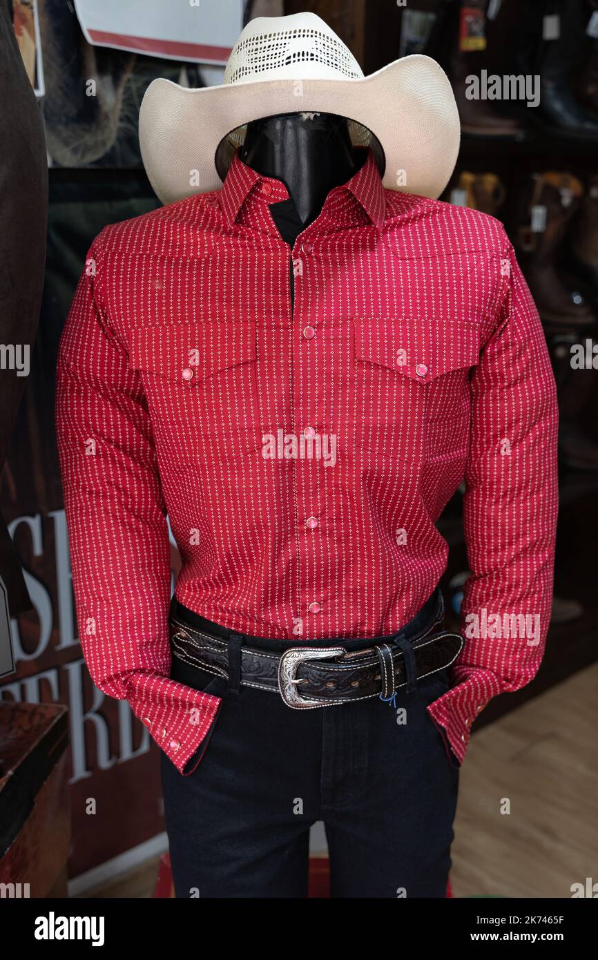 Chemise rouge Charro pour hommes, pantalon noir et chapeau blanc sur le mannequin du magasin. Vêtements de cow-boy mexicains traditionnels Banque D'Images