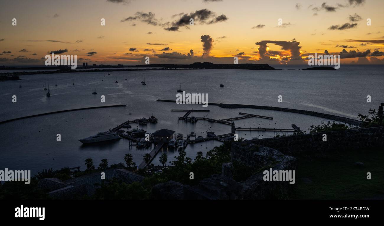 Vue sur le coucher du soleil depuis le fort Louis surplombant le port de Marigot, du côté français de l'île des Caraïbes de St Martin Banque D'Images