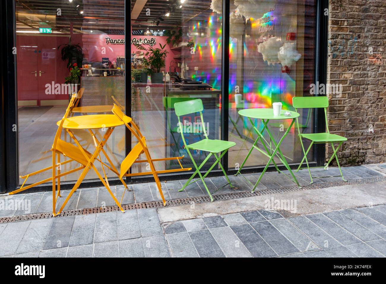 Chaises et tables en métal vert et orange devant un café à Camden Town, Londres, Royaume-Uni Banque D'Images