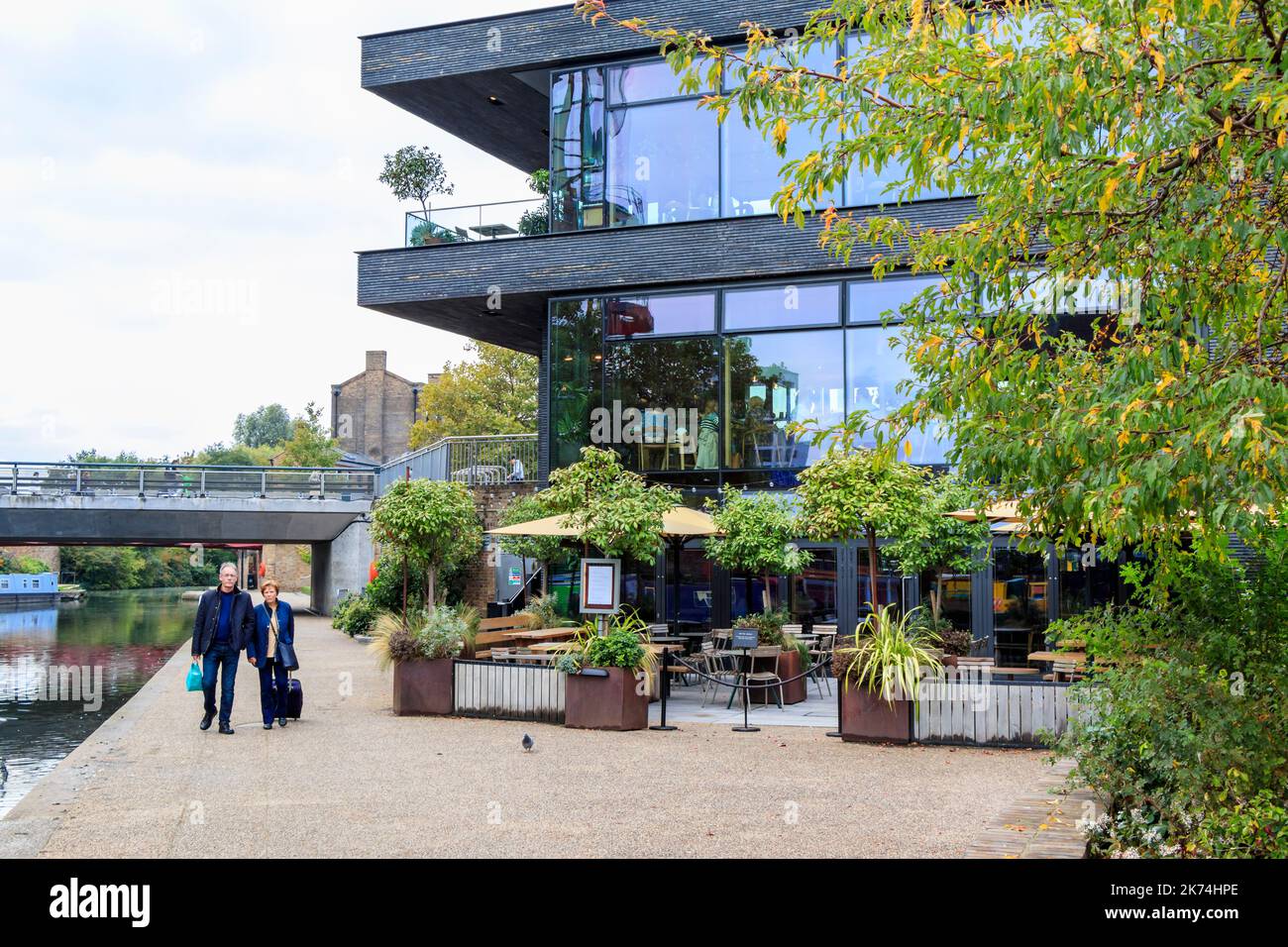 Une promenade en couple le long du chemin de halage du canal Regents à King's Cross, Londres, Royaume-Uni, le Lighterman gastropub sur la droite. Banque D'Images