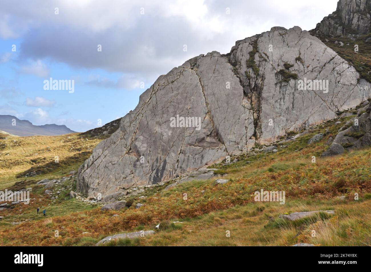 Immense dalle de roche près de Tryfan, une montagne de Snowdonia, pays de Galles, avec 2 randonneurs à gauche pour l'échelle Banque D'Images