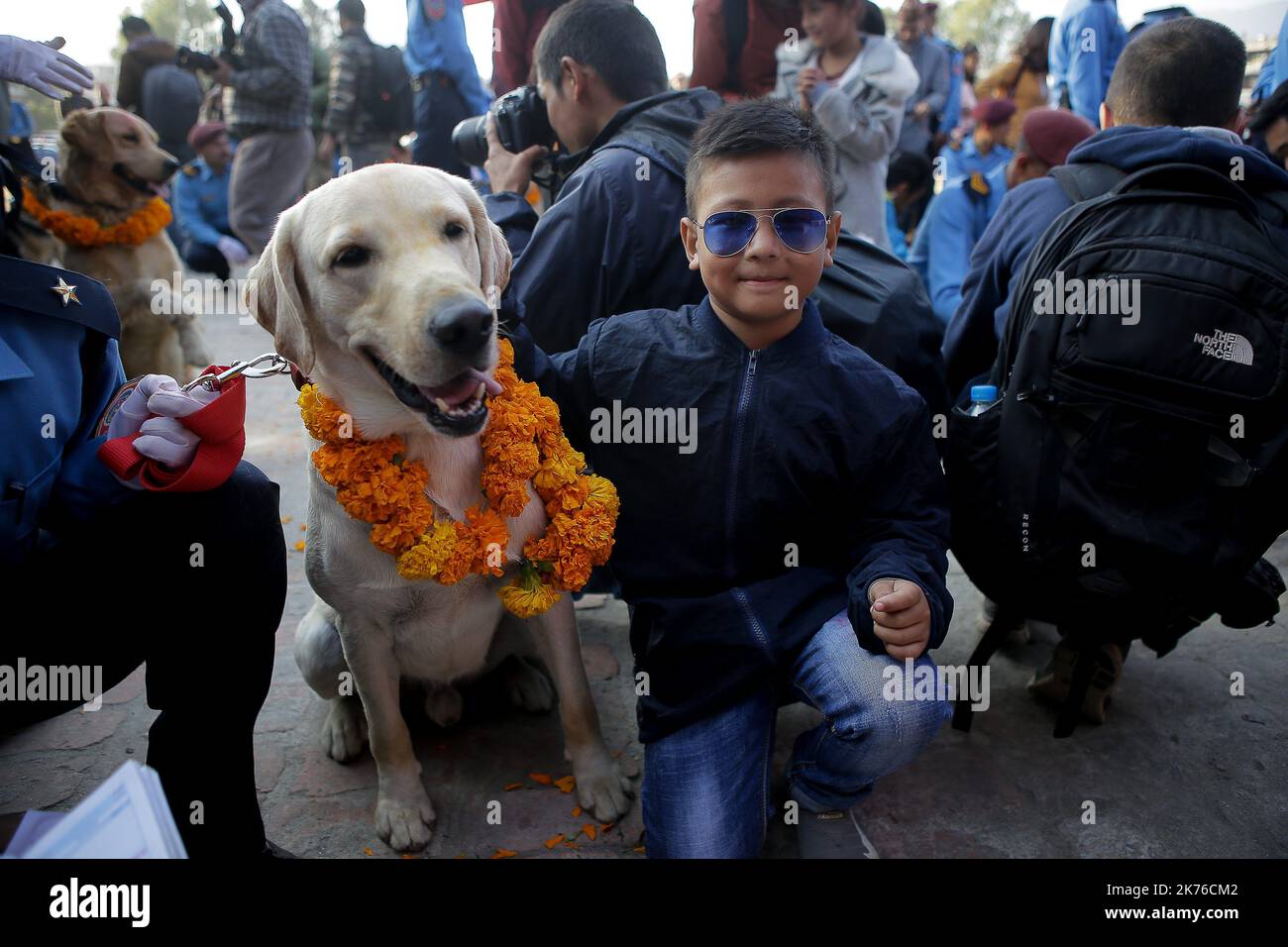 Un garçon pose pour une photo avec un chien de police après le culte pendant le KUKUR TIHAR ou le jour de culte de chien à Katmandou, au Népal sur 6 octobre 2018. Les chiens sont adorés pour reconnaître leur rôle dans la sécurité et être humains meilleur ami, le deuxième jour de la plupart des festivals hindous importants Tihar qui est également consacré à l'adoration de la déesse de la richesse Laxmi. (Photo-Sunil Pradhan) Banque D'Images