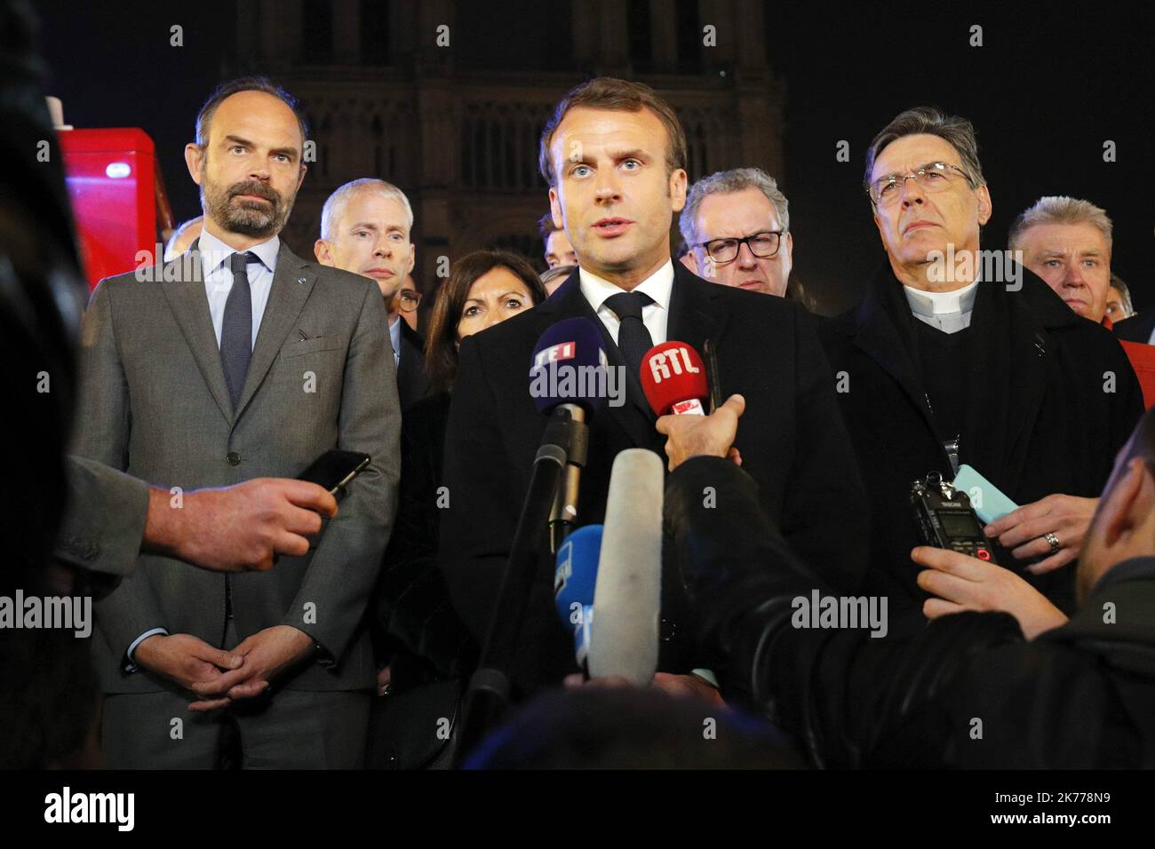 Le président français Emmanuel Macron s'exprime en tant que Premier ministre Edouard Philippe et archevêque de Paris, Michel Aupetit, se trouve près de la cathédrale notre-Dame où un feu brûle à Paris, en France. Banque D'Images