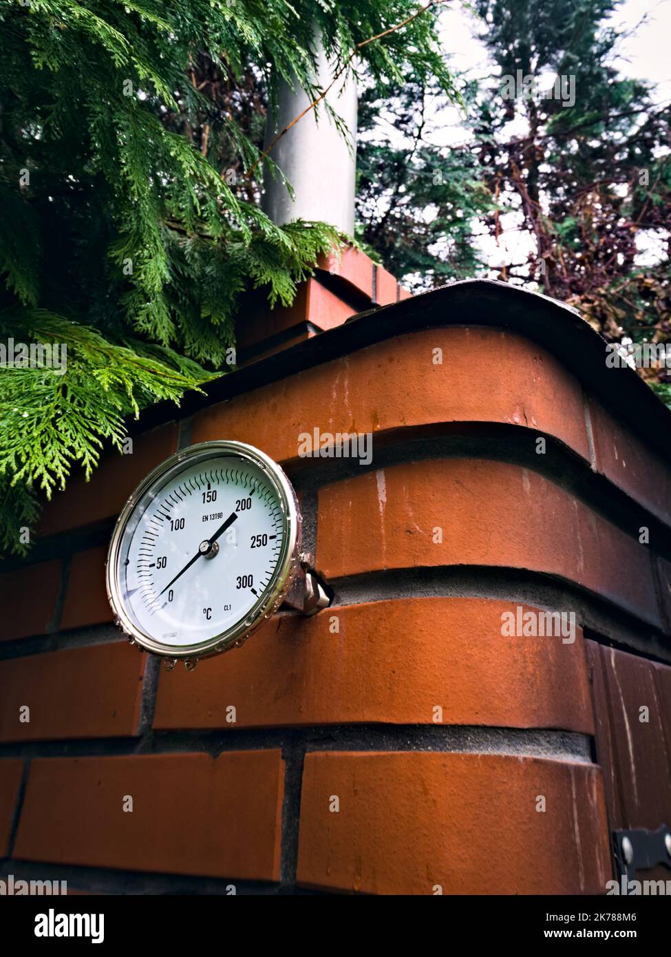 Fumoir de jardin avec un thermomètre installé pour contrôler la température pendant le tabagisme des viandes séchées Banque D'Images