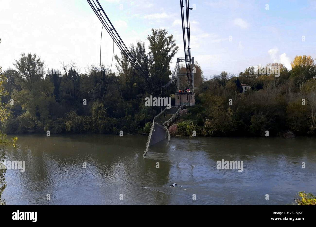 Une jeune fille de 15 ans est morte et plusieurs personnes sont probablement disparues après l'effondrement lundi d'un pont dans une rivière du sud-ouest de la France, ont déclaré les services d'urgence. Le pont suspendu de 150 mètres de long à Mirepoix-sur-Tarn, près de Toulouse, s'est effondré alors qu'un camion, une voiture et peut-être une fourgonnette traversaient, a déclaré le procureur local. Le pont était limité à des véhicules de 19 tonnes. Banque D'Images