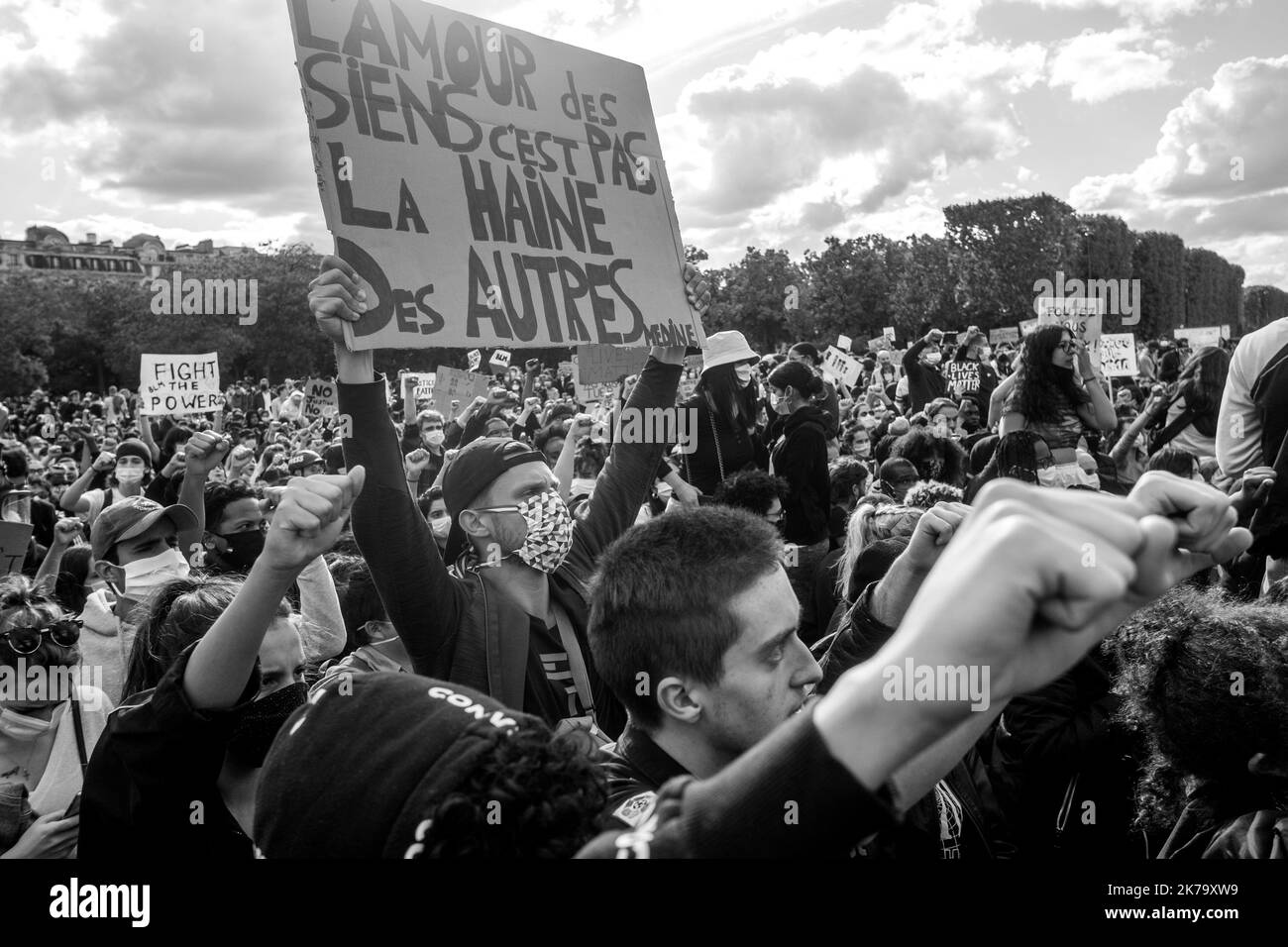France / Ile-de-France (région) / Paris - les manifestants élèvent leurs poings en l'air et s'agenouillent sur le terrain pour rendre hommage à George Floyd lors d'un rassemblement contre la violence policière et le racisme sur le champ de Mars. George Floyd est mort lors de son arrestation par un policier blanc, Derek Chauvin, 25 mai 2020 à Minneapolis, Minnesota, aux États-Unis. De récentes enquêtes sur le racisme dans la police viennent d'être publiées dans la presse française et trouvent écho à la mort de George Floyd aux États-Unis. Dans de nombreux pays, des manifestations ont lieu en réponse à la mort de George Floyd. Banque D'Images